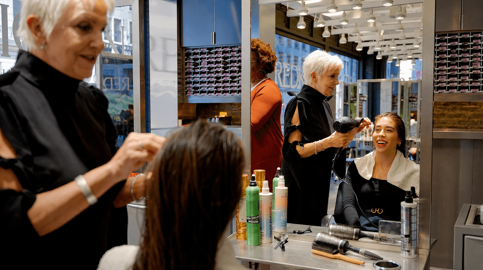 L'Oréal professional salon - stylist working on her client, having a great time.