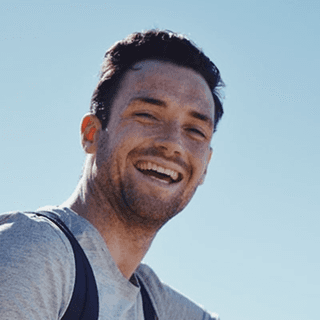 Man laughing outdoors in sunlight