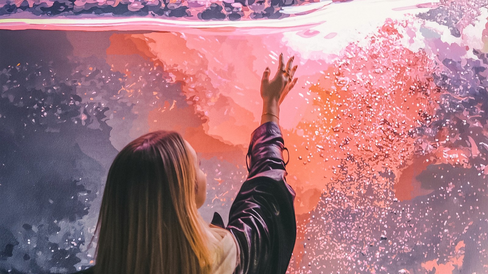 Személy nyújtózkodik az élénk absztrakt művészet felé a Borélményen.