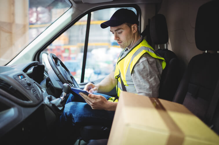 Delivery driver checking tablet inside va