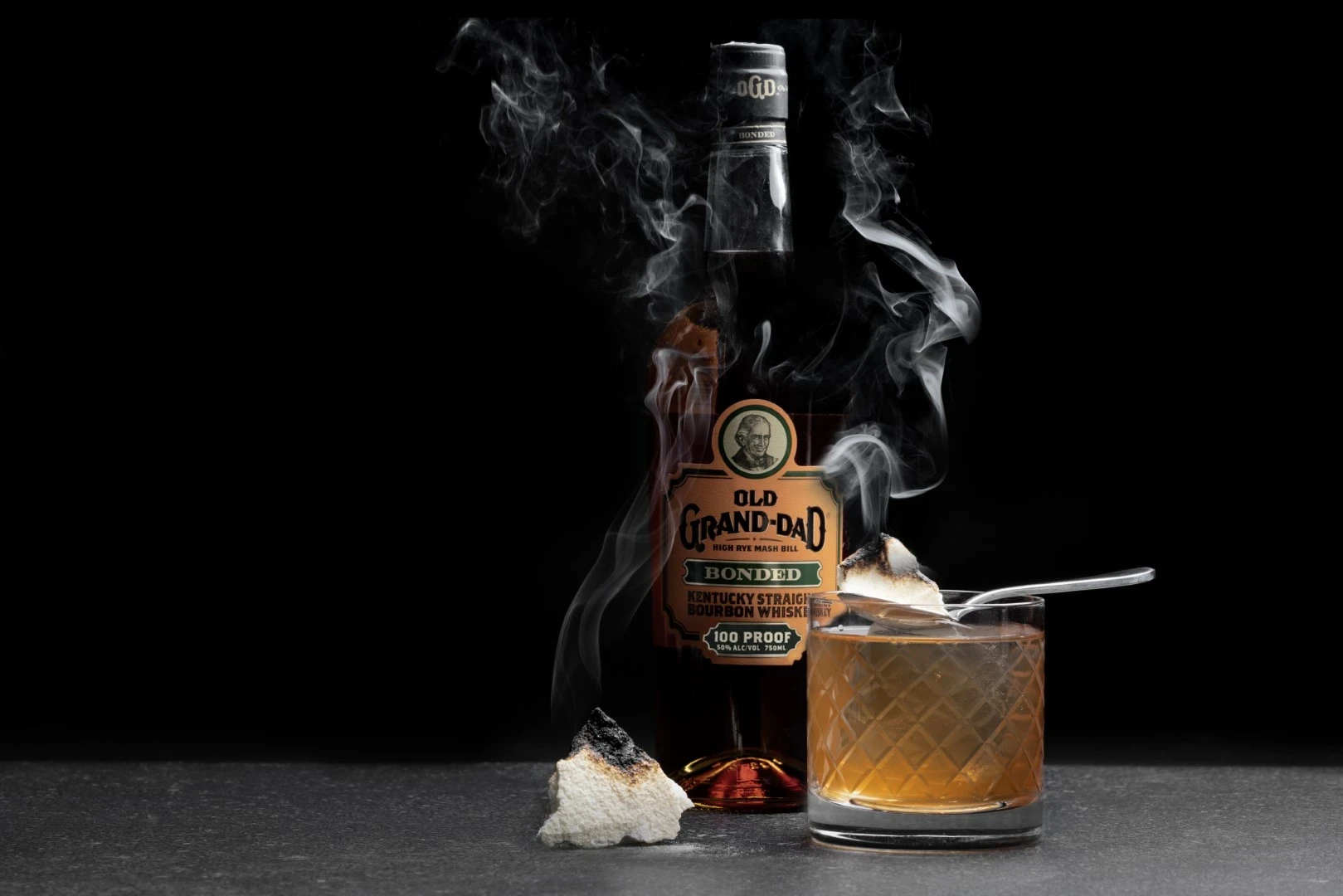 “Old Grand-Dad Bonded Bourbon with a smoked cocktail. Premium whiskey-based drink with fire-infused flavors.”