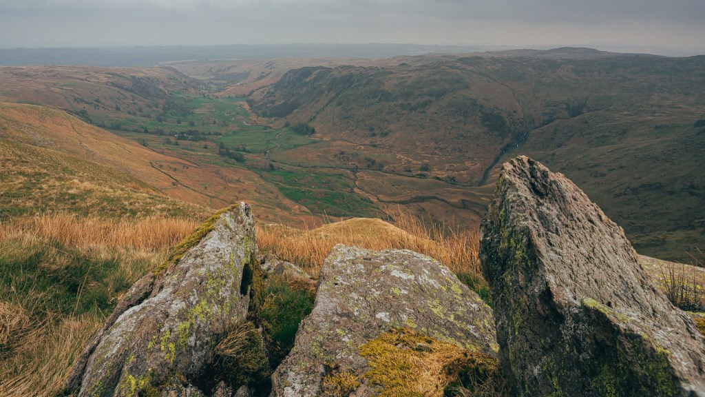 Swindale valley through an arrangement of rocks from Selside Pike. The rocks frame the valley, pointing towards it.