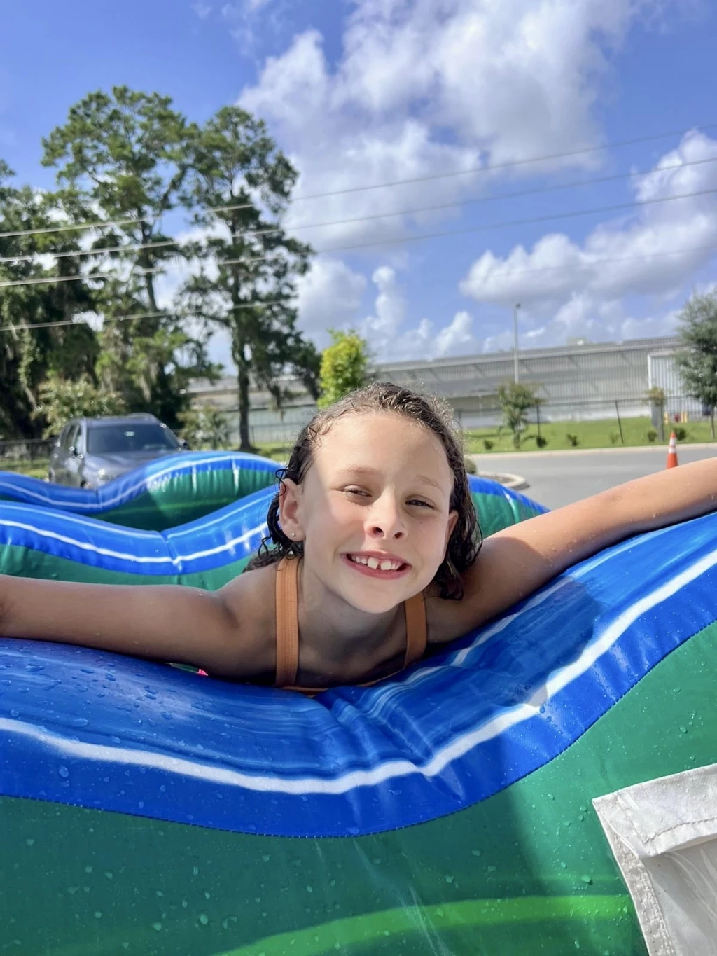 Group of kids smiling while petting an animal.