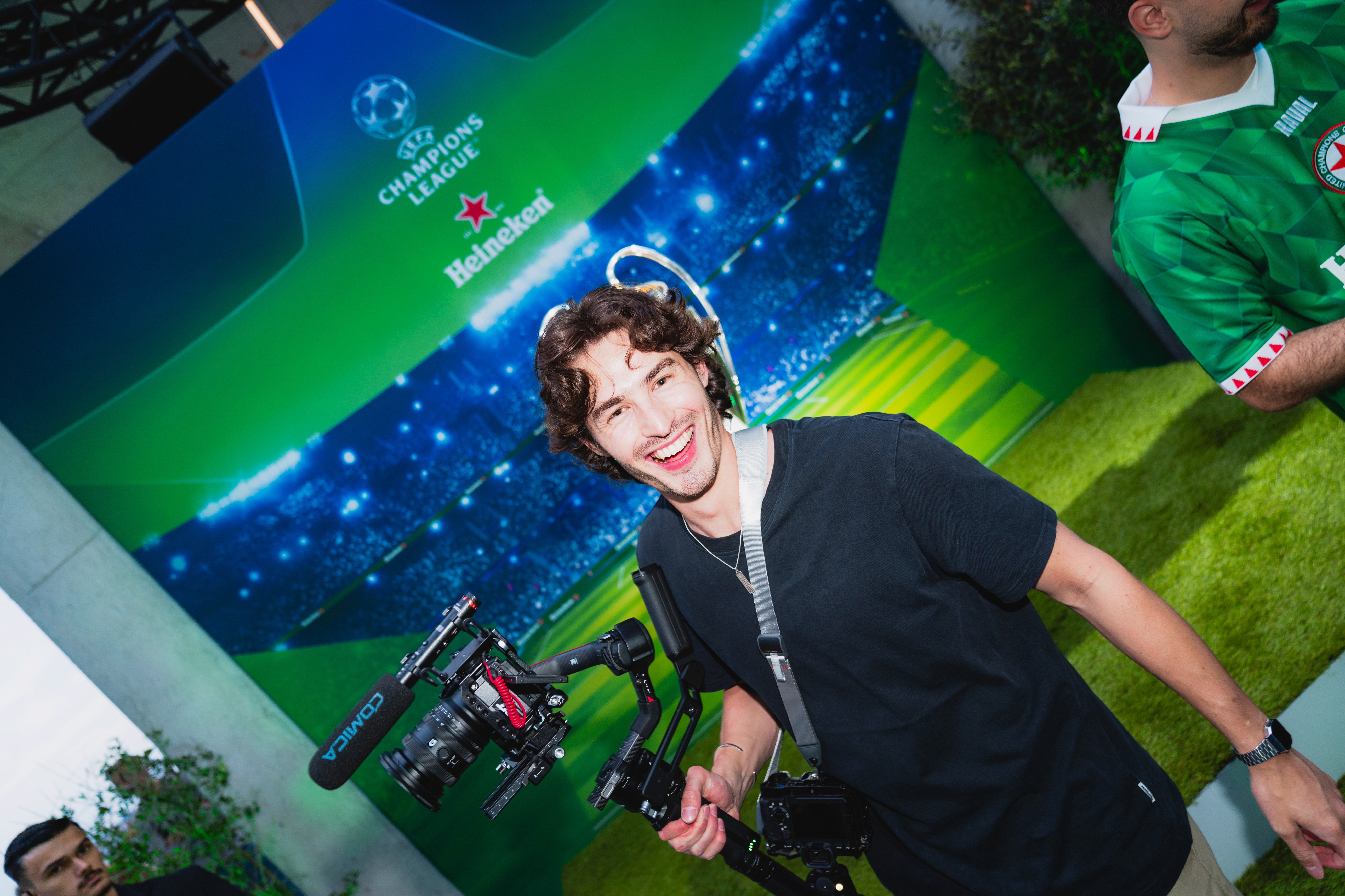 Modern red brick apartment or office building viewed from below against a blue sky, showcasing its geometric architecture with evenly spaced windows and balconies.
