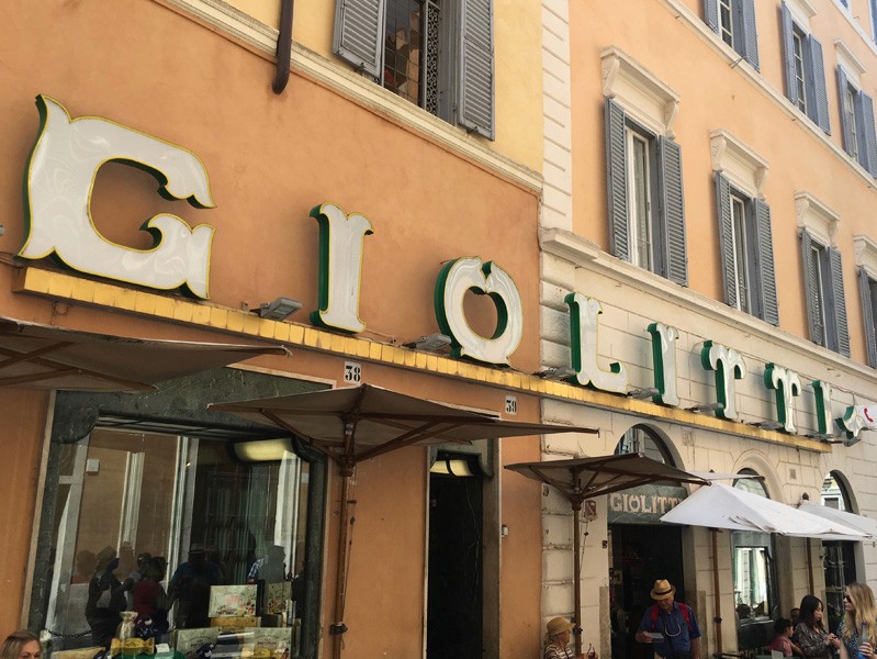 A building with store fronts and some old 3d text on top that says: GIOLITT.