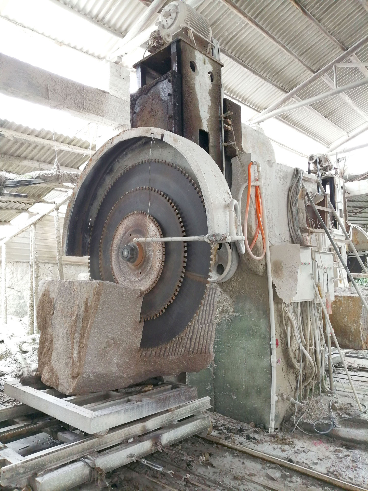 Dinosaw Single Column Auto Cutting Machine in operation, showing the stability and strength of the machine while handling a large stone block.