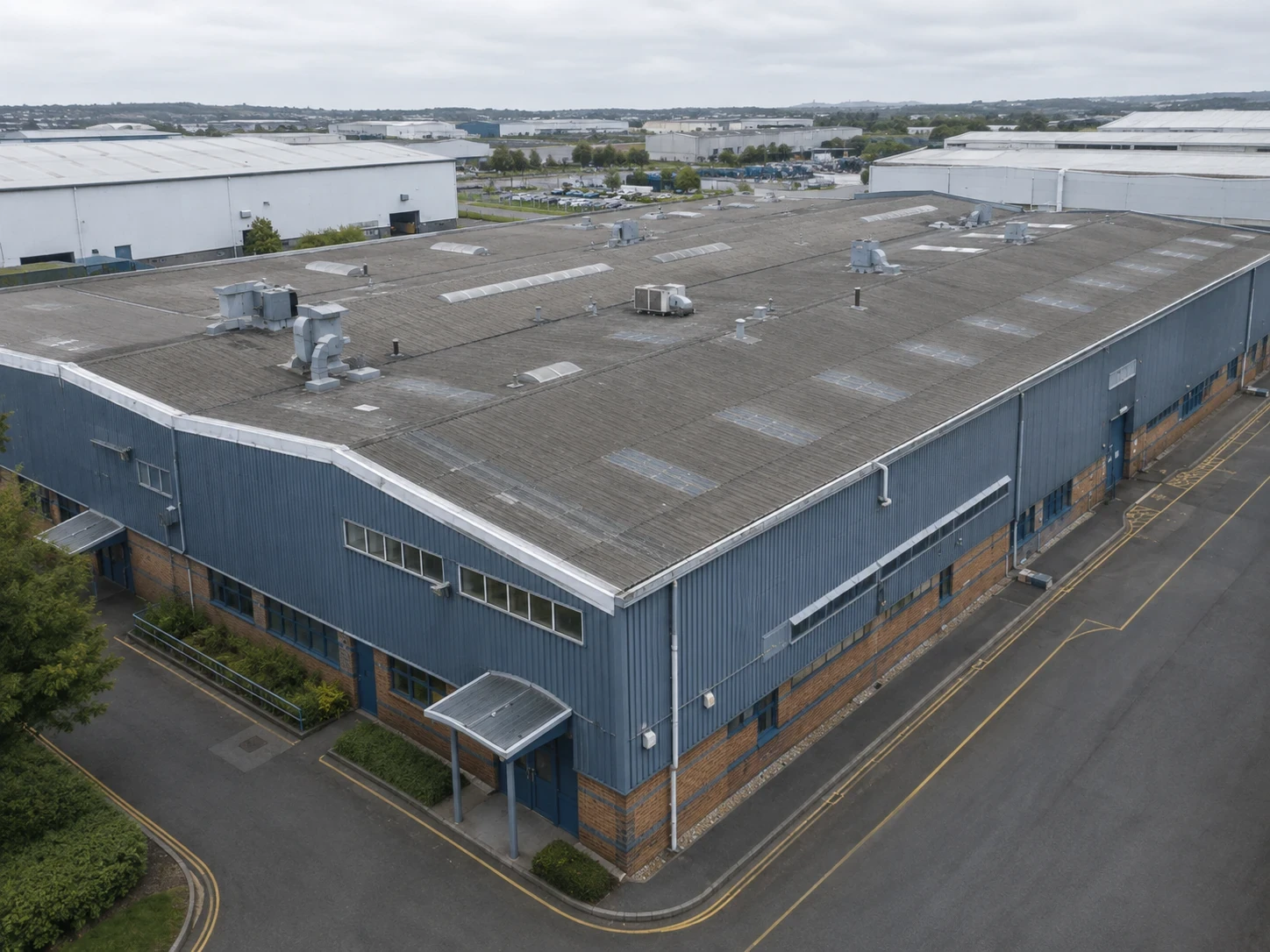 Drone view along the elevation of an industrial building showing cladding and roofline