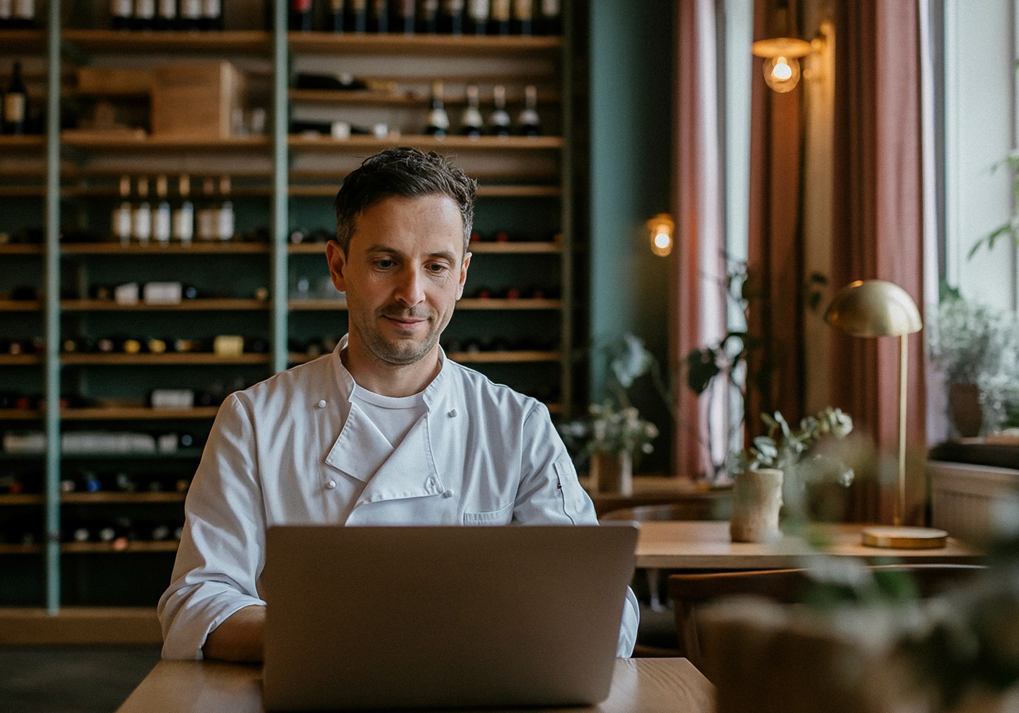 Chef doing accounting on his laptop in a restaurant