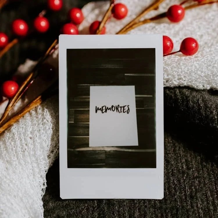 a polaroid with an image of a card on which is written, "MEMORIES"