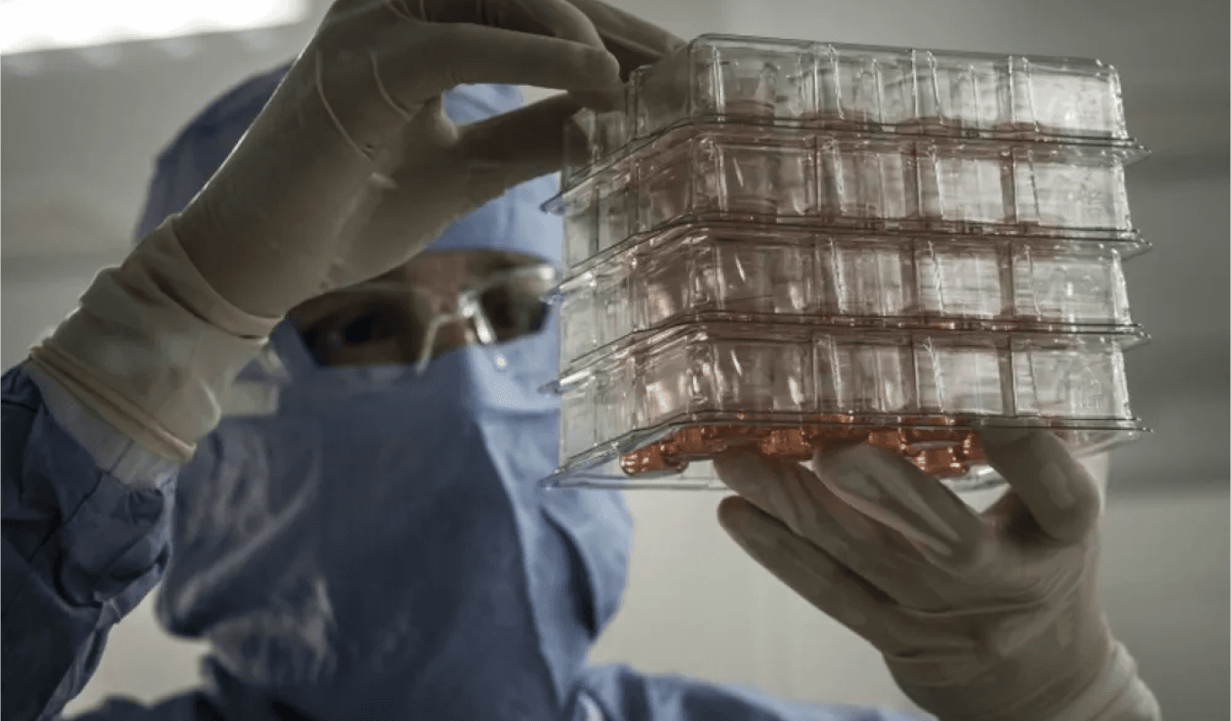 In a lab, a man holds a box of plastic, highlighting his research and experimentation.
