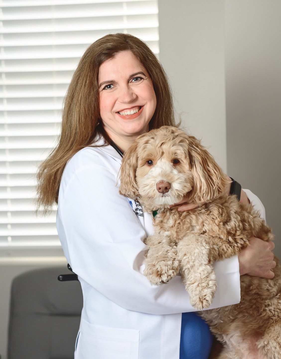 Rheumatologist holding her therapy dog pasha