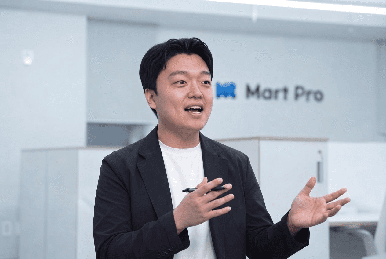 마트프로 이보성 대표가 Mart Pro 로고 앞에서 마트 통합 관리 솔루션 비전을 설명하는 모습