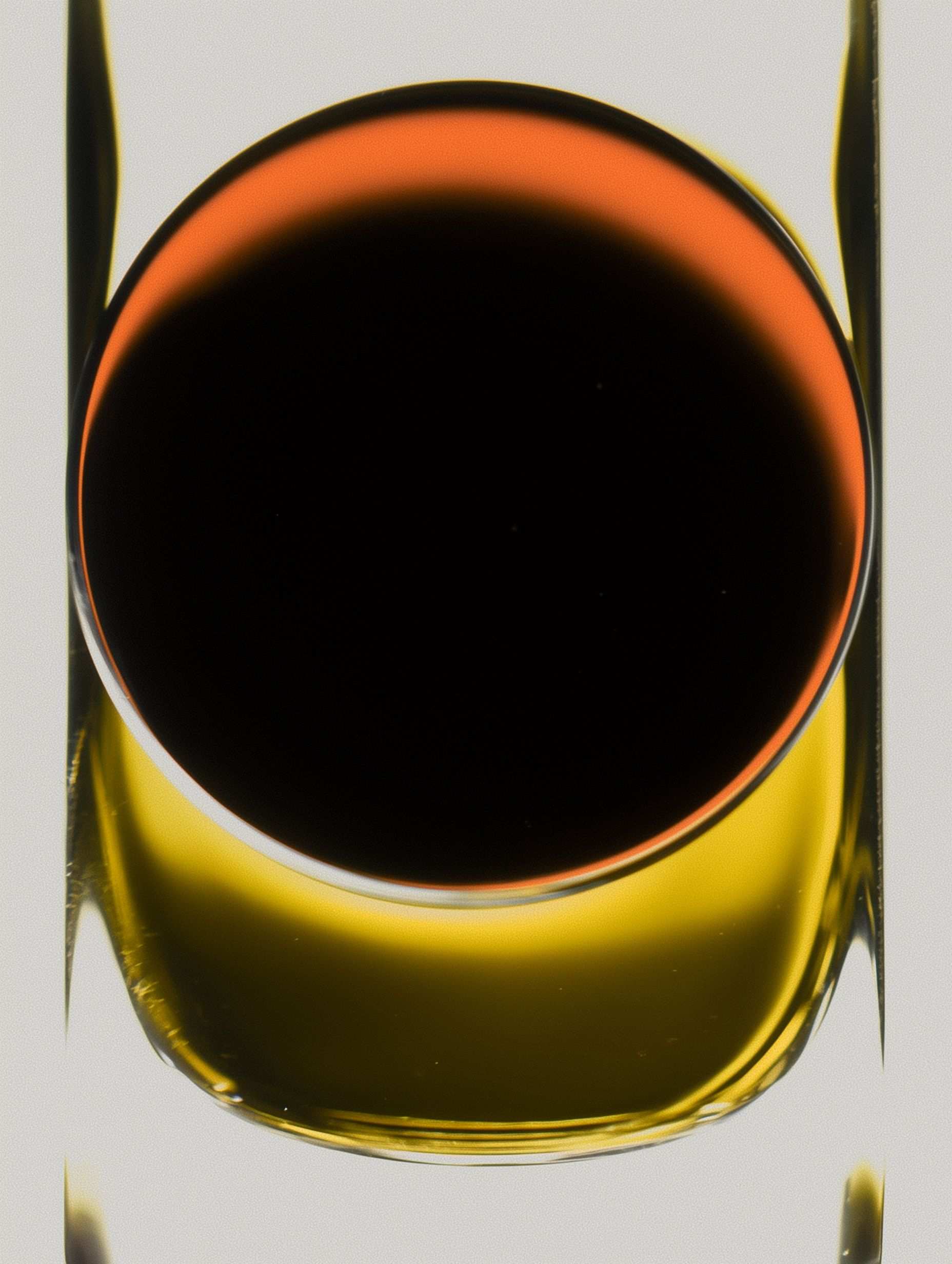 Overhead view of amber liquid in round glass container