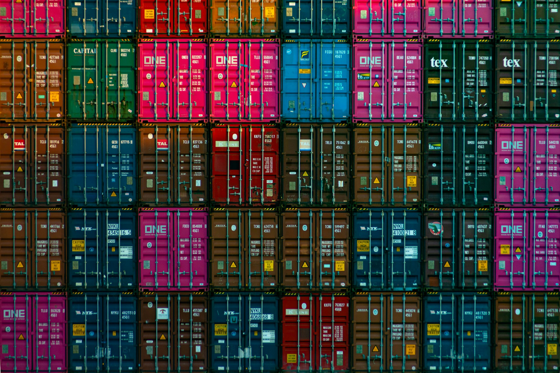 A colorful stack of shipping containers arranged in neat rows, symbolizing the global scope of commodities trading and international trade logistics.
