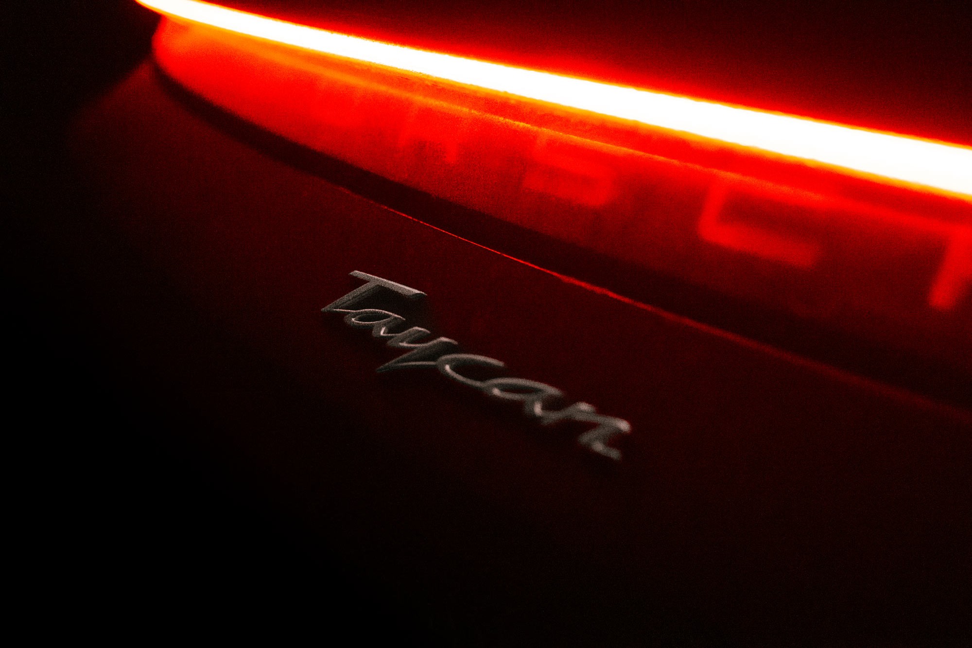 Taycan emblem with glowing red lights; Filmproduction, Campaign, Photography.