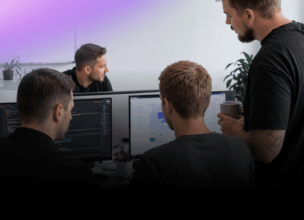 Nextio developers collaborating on custom software development and coding a web application on dual monitors.