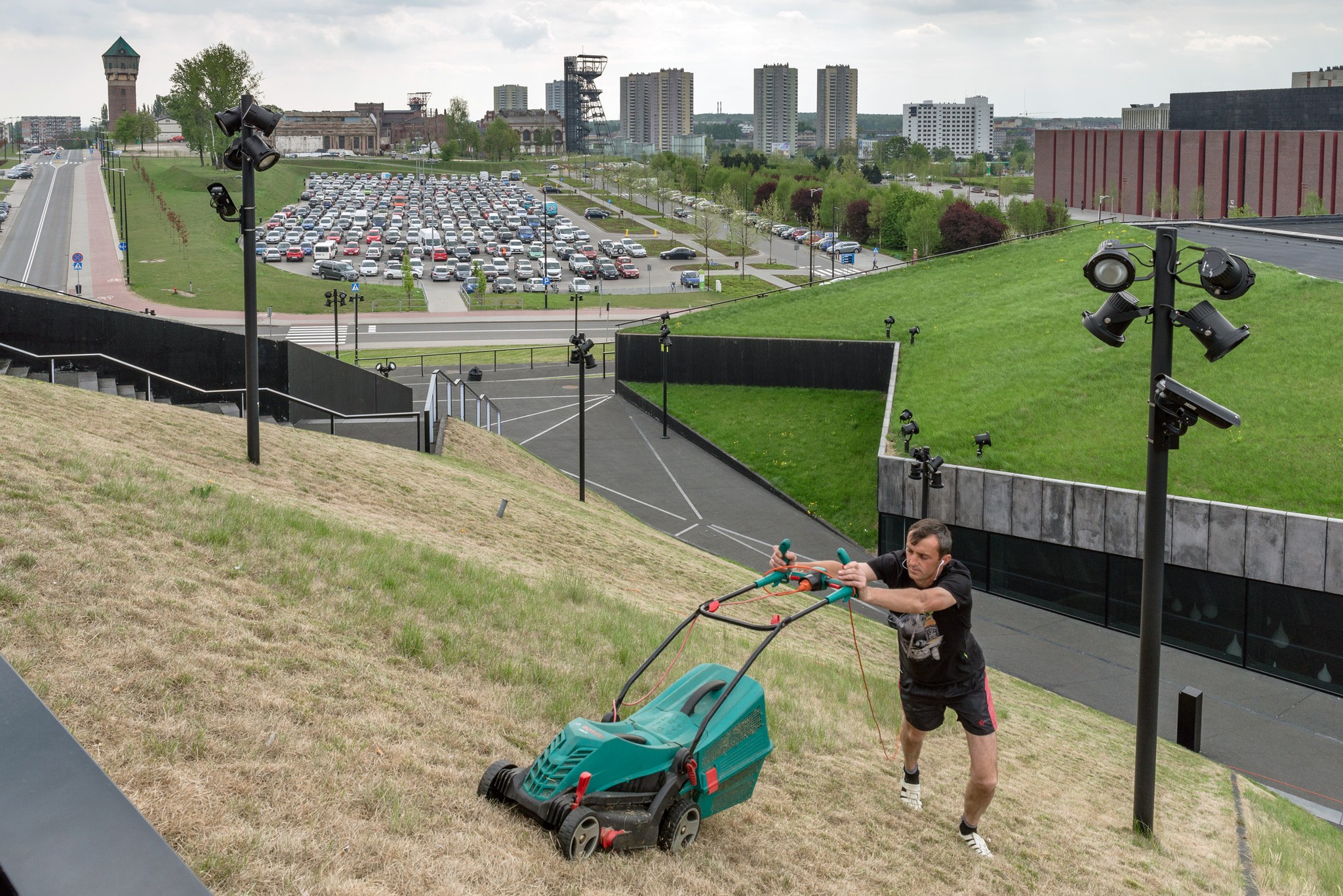 koszący trawę mężczyzna w pochmurny dzień