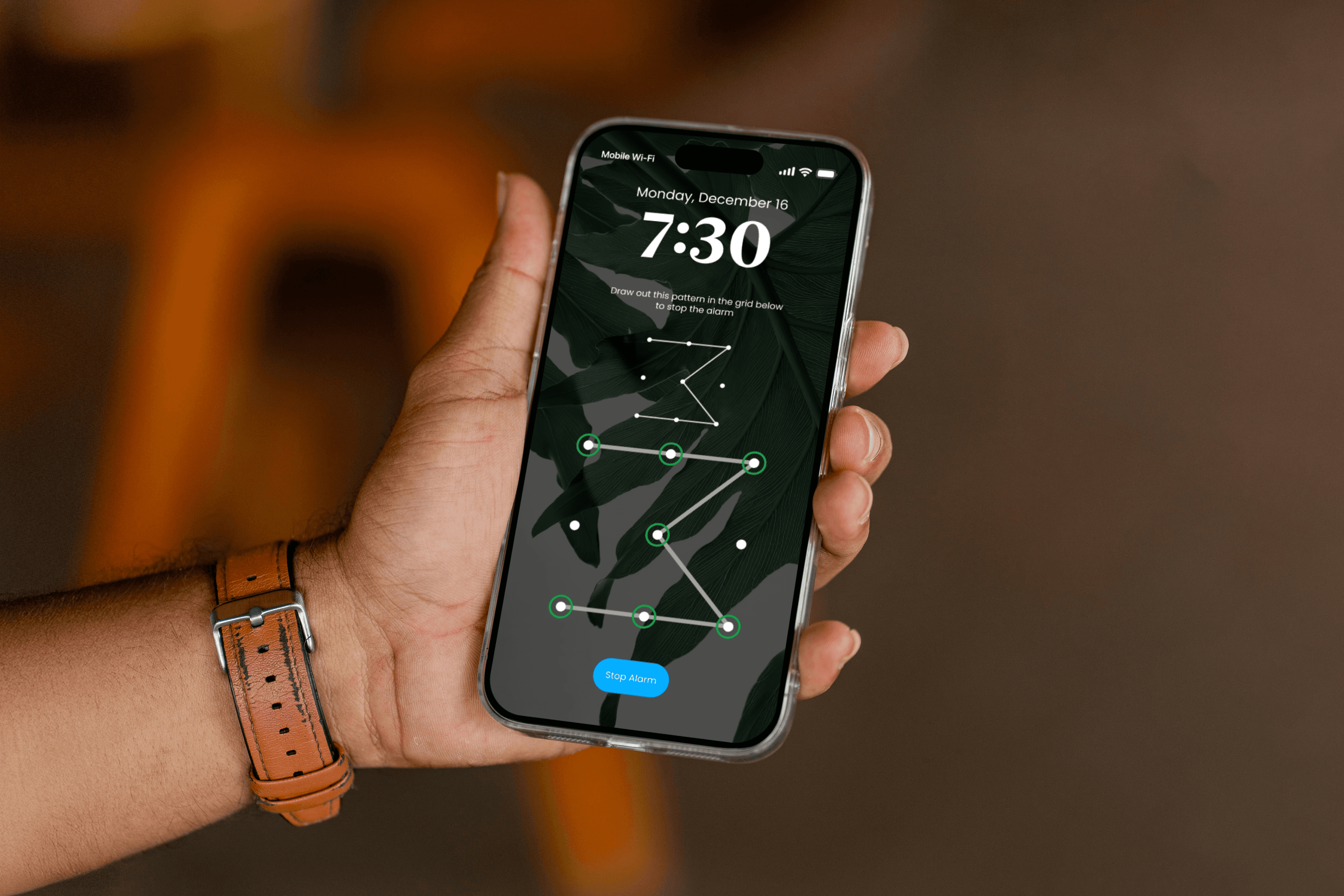 Person holding a phone with the initial Cognitive Alarm screen.