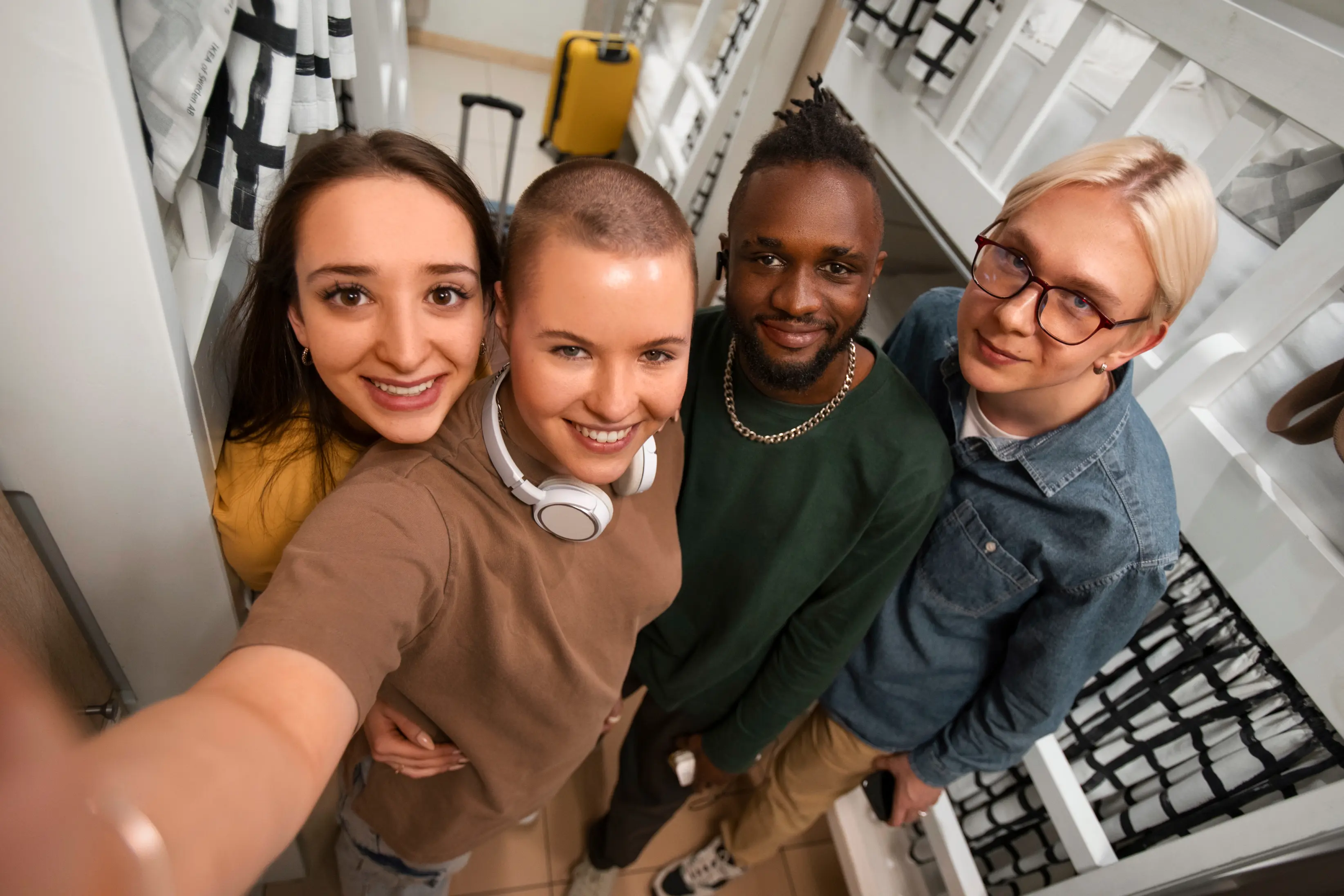 Photo of four people standing in fronnt of a camera and smiling