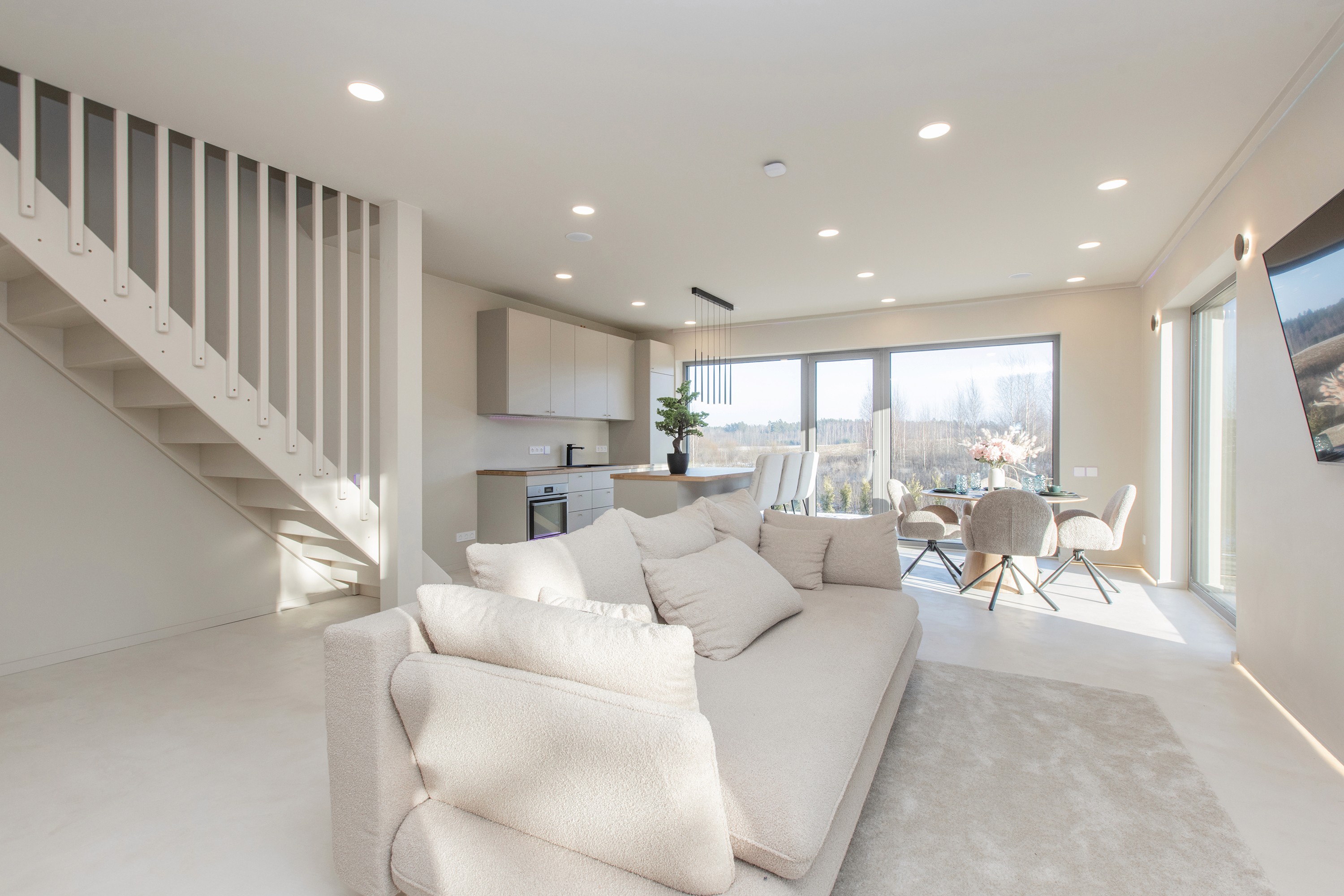 Open-concept living area and staircase showing the modern interior layout of tokenized rental properties in Priežavoti Village.