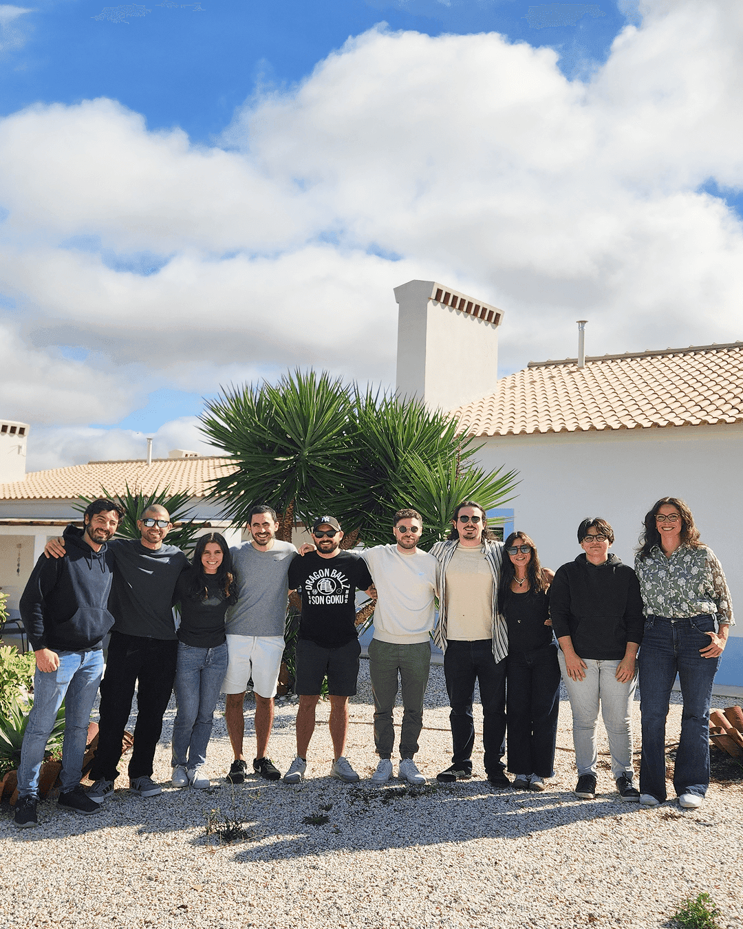 Concealed team photo with all ten members smiling and looking at the camera.