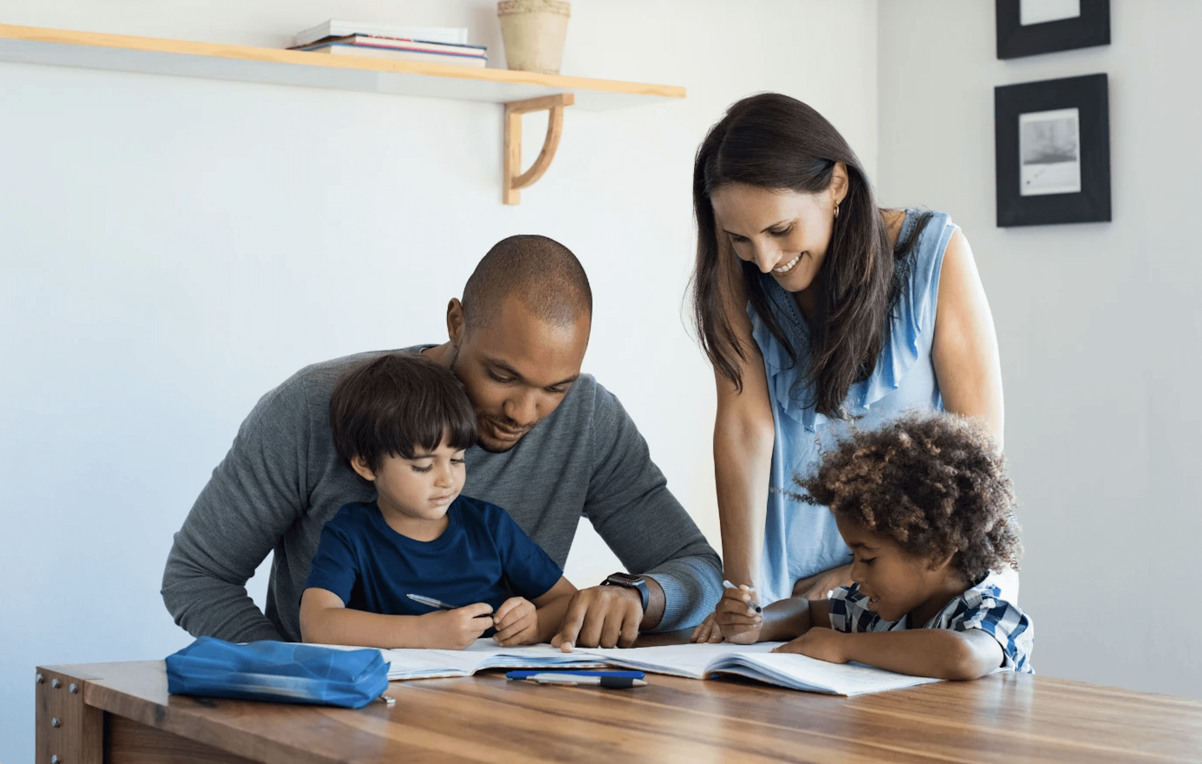 family sitting around kitchen table looking at books