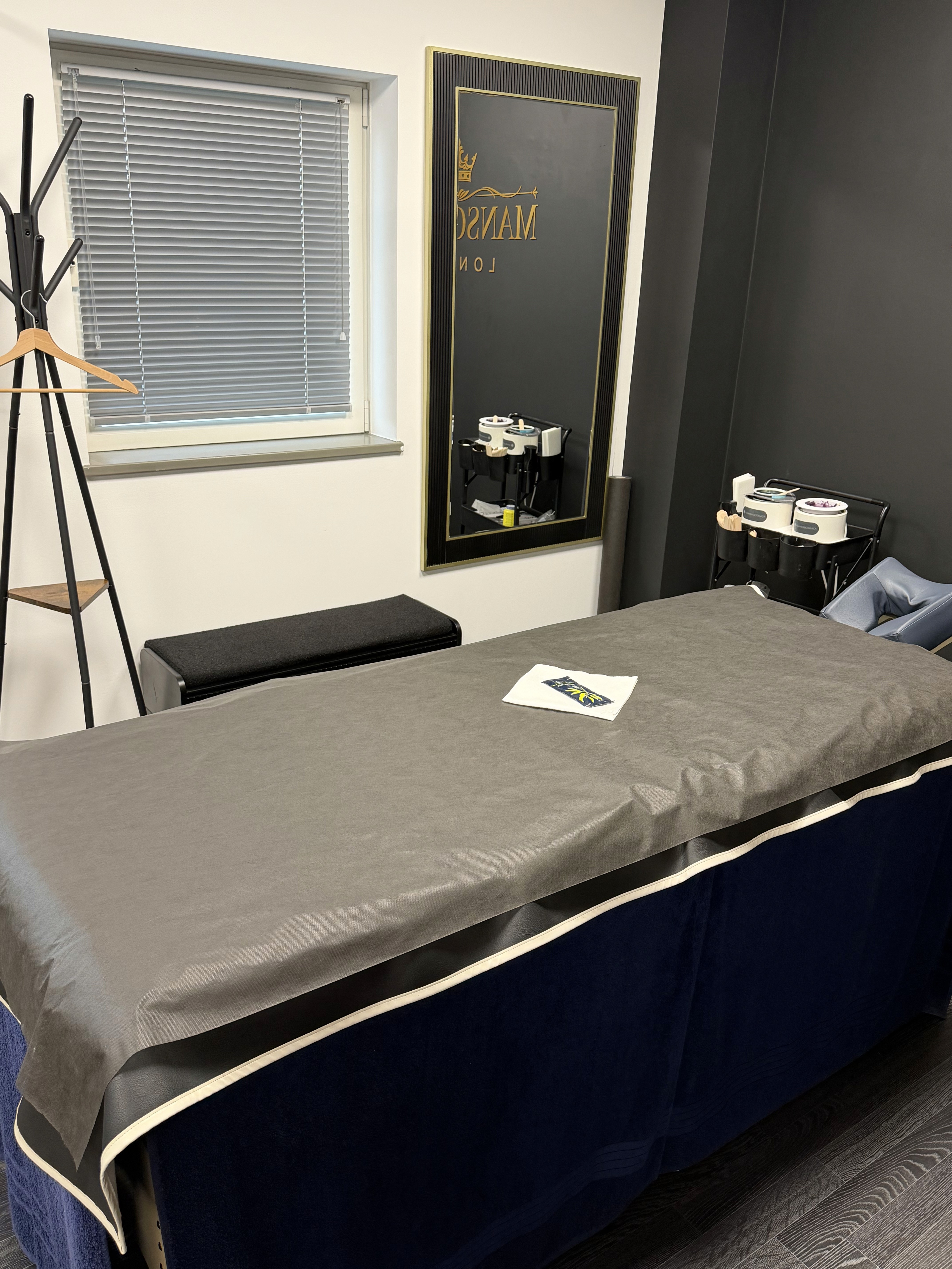 Clients area, featuring a clothing hanger, little side table and mirror
