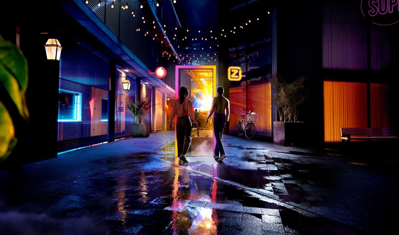 People standing near a lit up street at night.