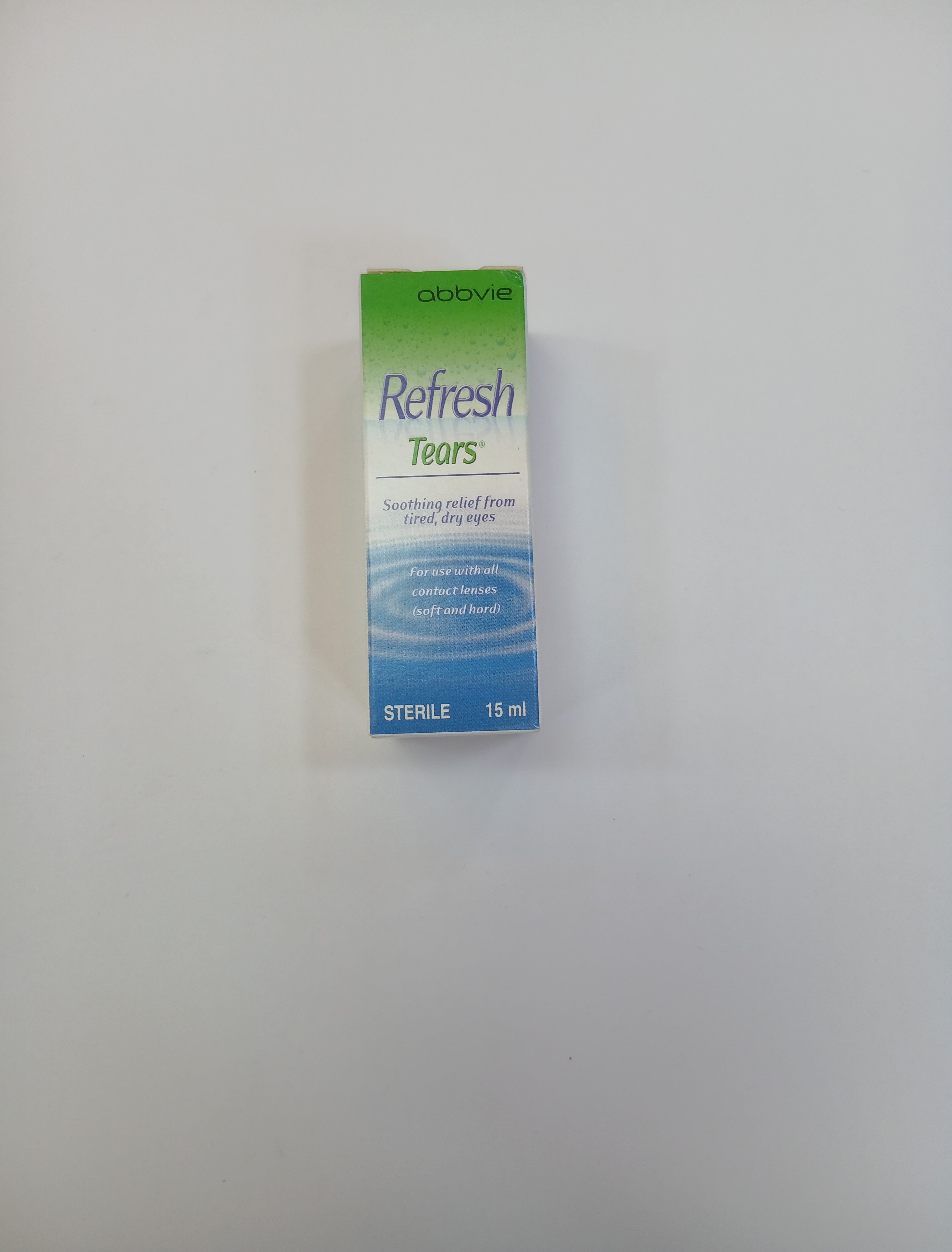 A small white and green rectangular box packaging with blue text and a sterile dropper cap, standing upright against a plain light background.