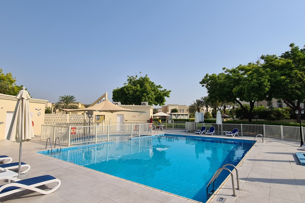 A picturesque canal surrounded by lush trees and colorful flowers, showcasing the beauty of a spring day in the park.