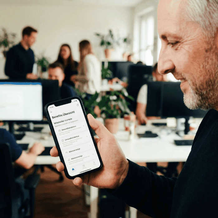 Mitarbeiter prüft seine Benefits in der Gesundheits-App auf dem Smartphone