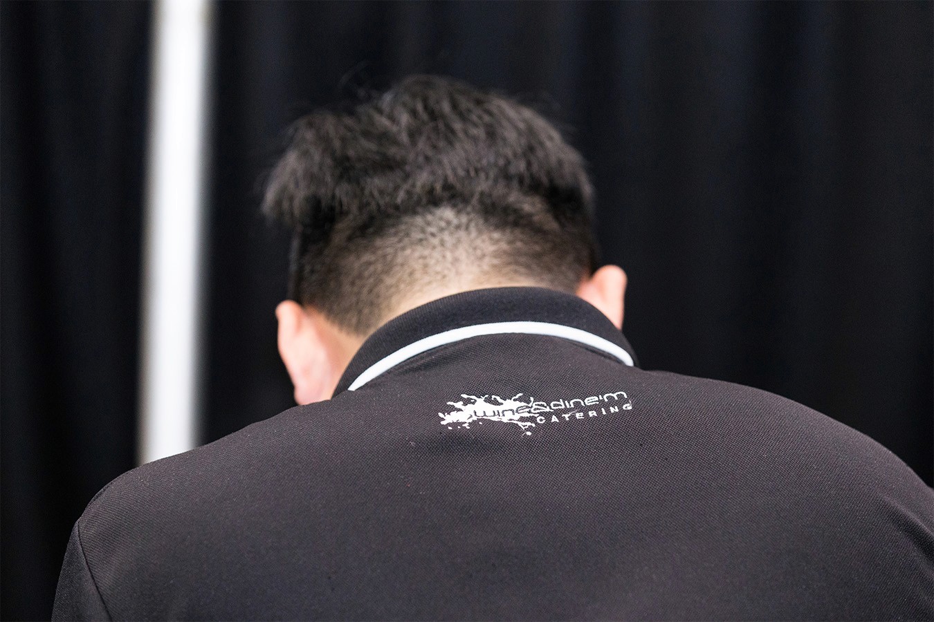 Old Wine & Dine'm logo on the back of chef's uniform