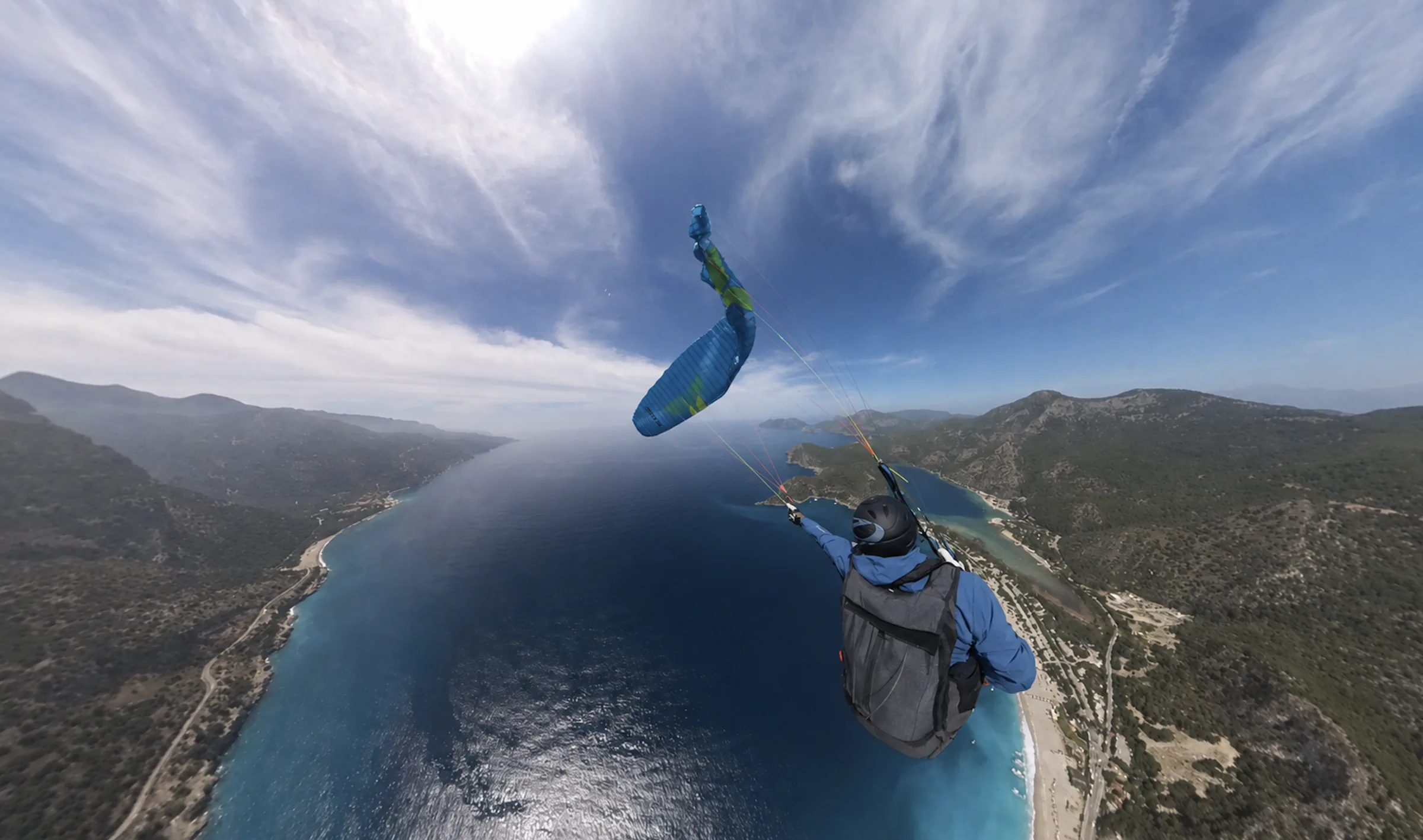 Pilot controlling a blue paraglider during autorotation training