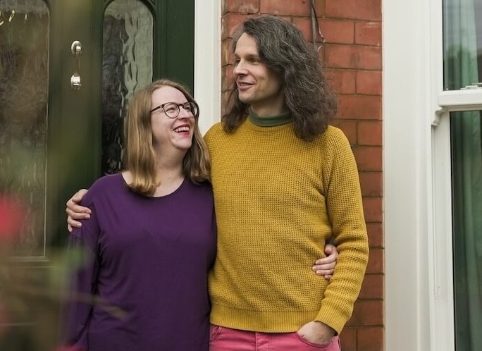 Woman smiling outside the front of her home.