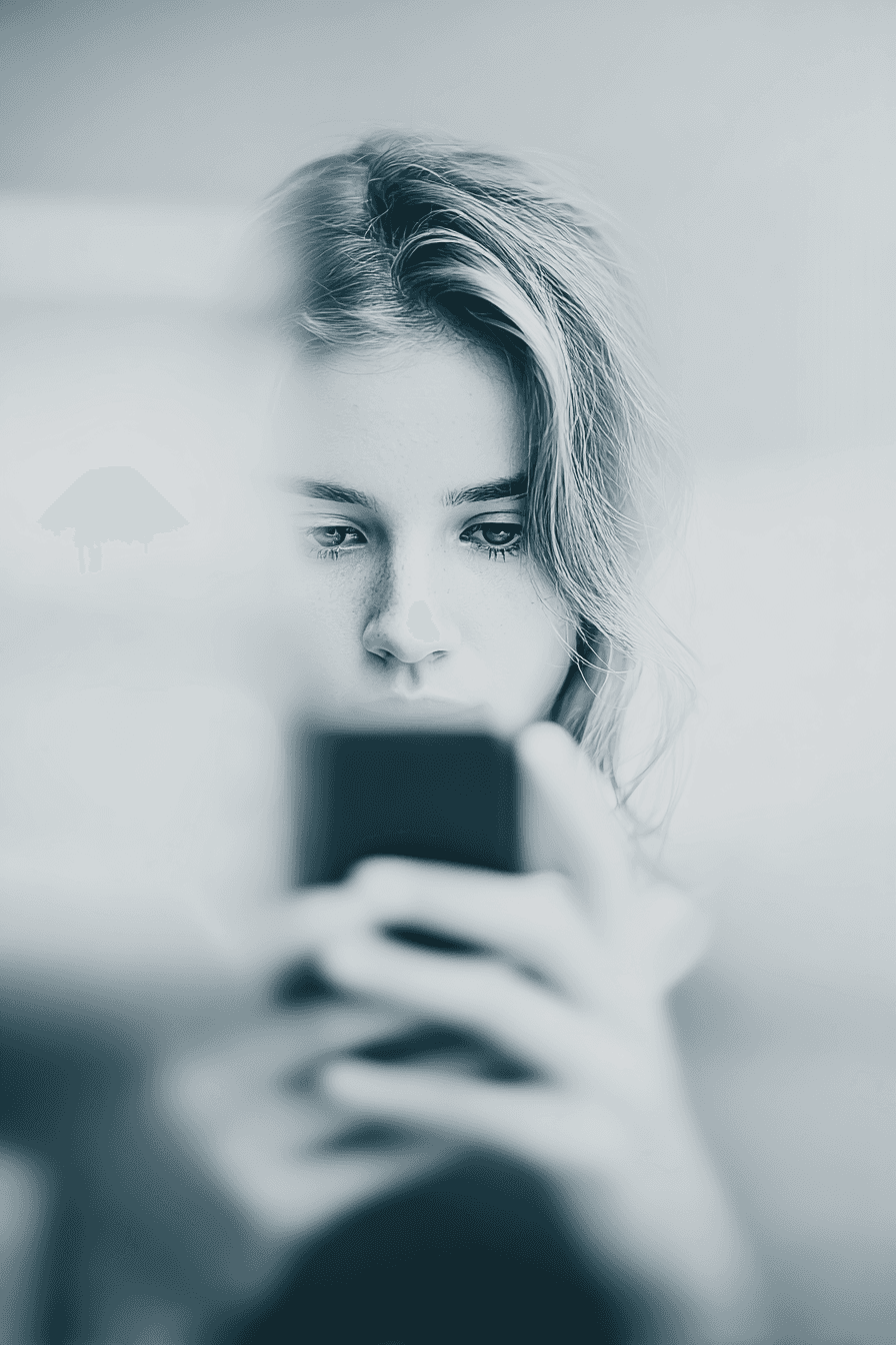A smiling young man with crossed arms, wearing a plaid shirt and white t-shirt, poses against a dark background.