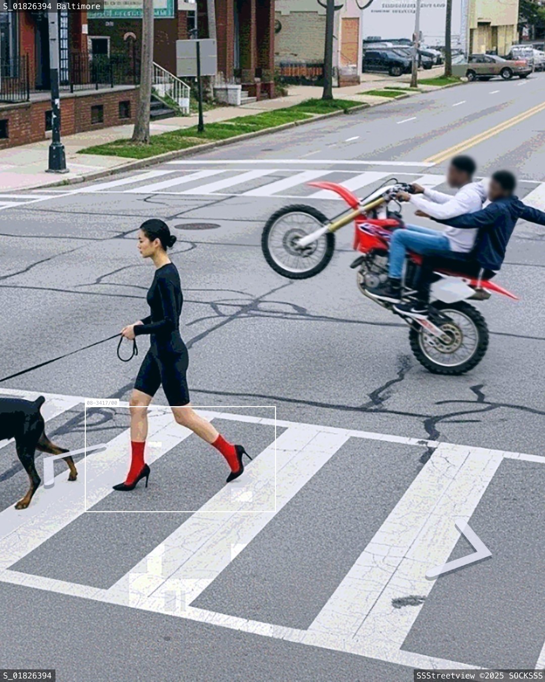 Une femme avec des chaussettes rouges traverse la rue avec son chienpendant qu'une moto fait un wheeling