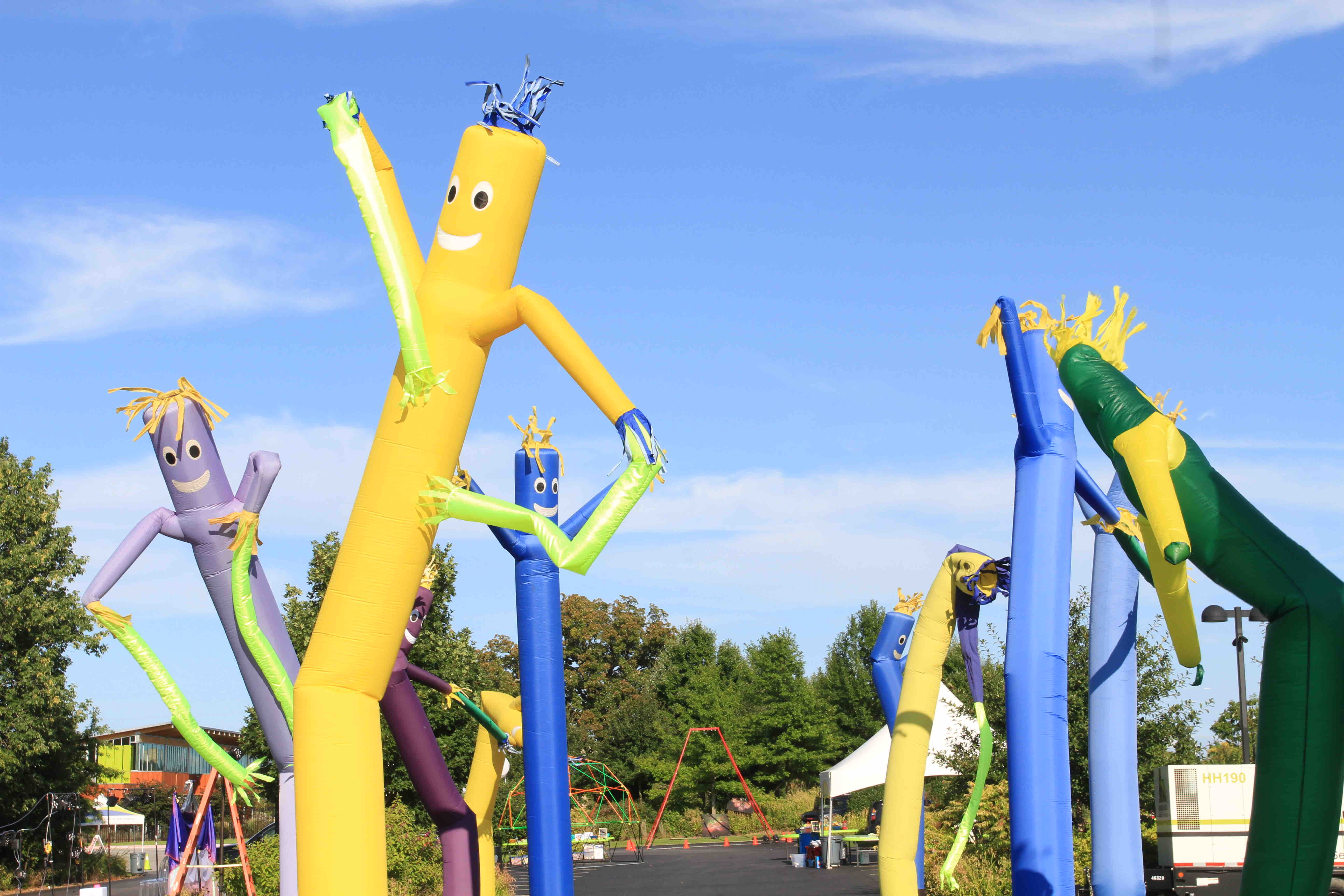 Colorful abstract sculptures in vibrant yellow, blue, and green against a clear blue sky.