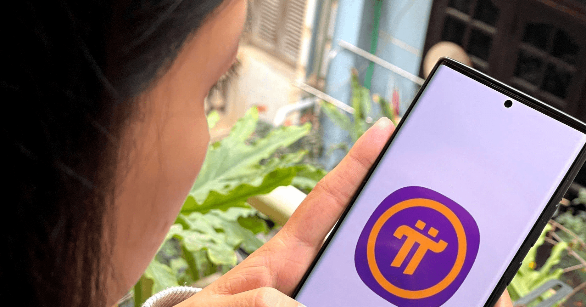 Woman viewing Pi Network on smartphone - Pi Network Tokenomics