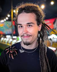 Portrait of a man with short brown hair, grey shirt, calm expression.