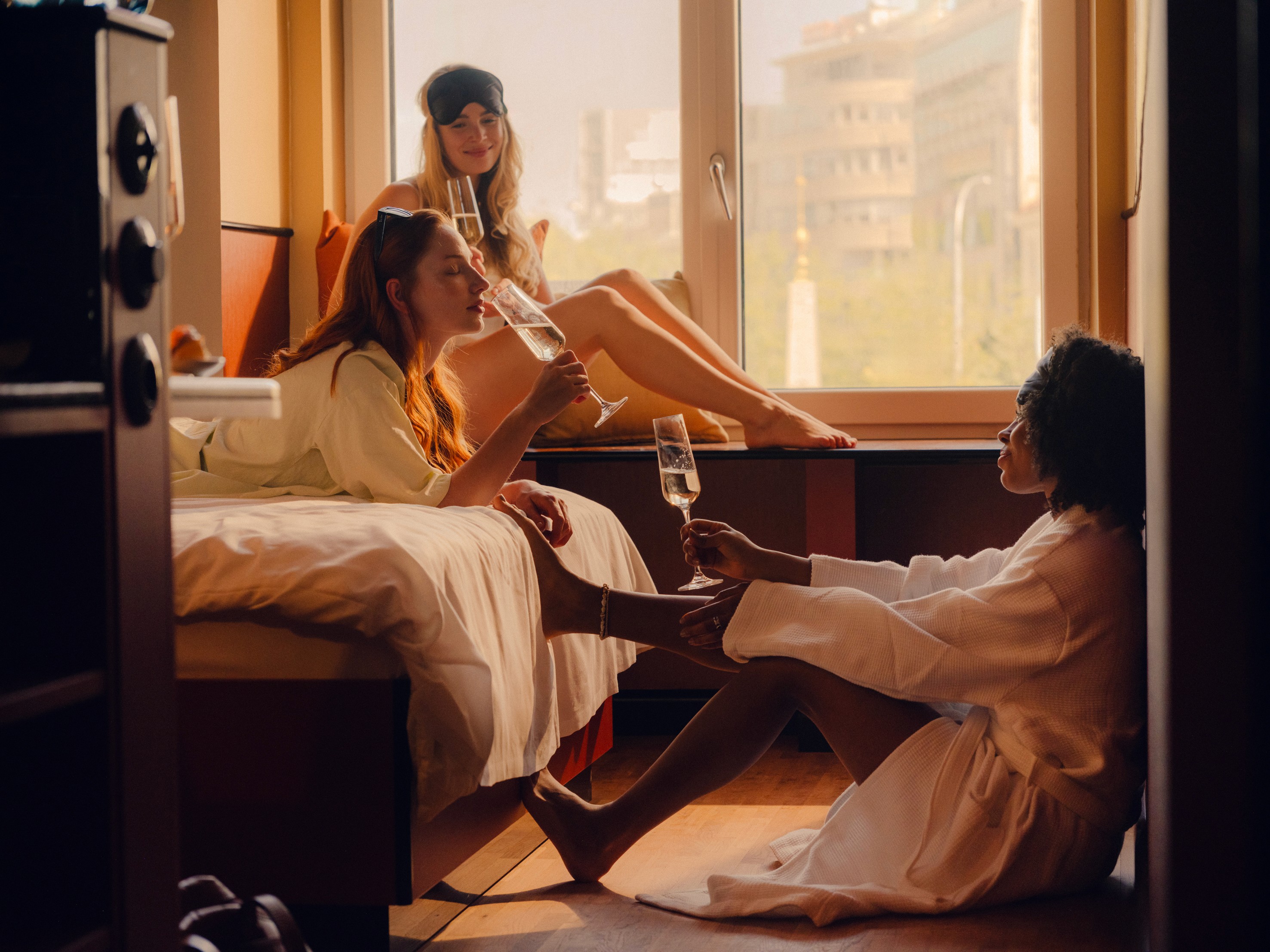 Three friends hanging out and drinking champagne at the "Roomies" Room at the Companion Vienna