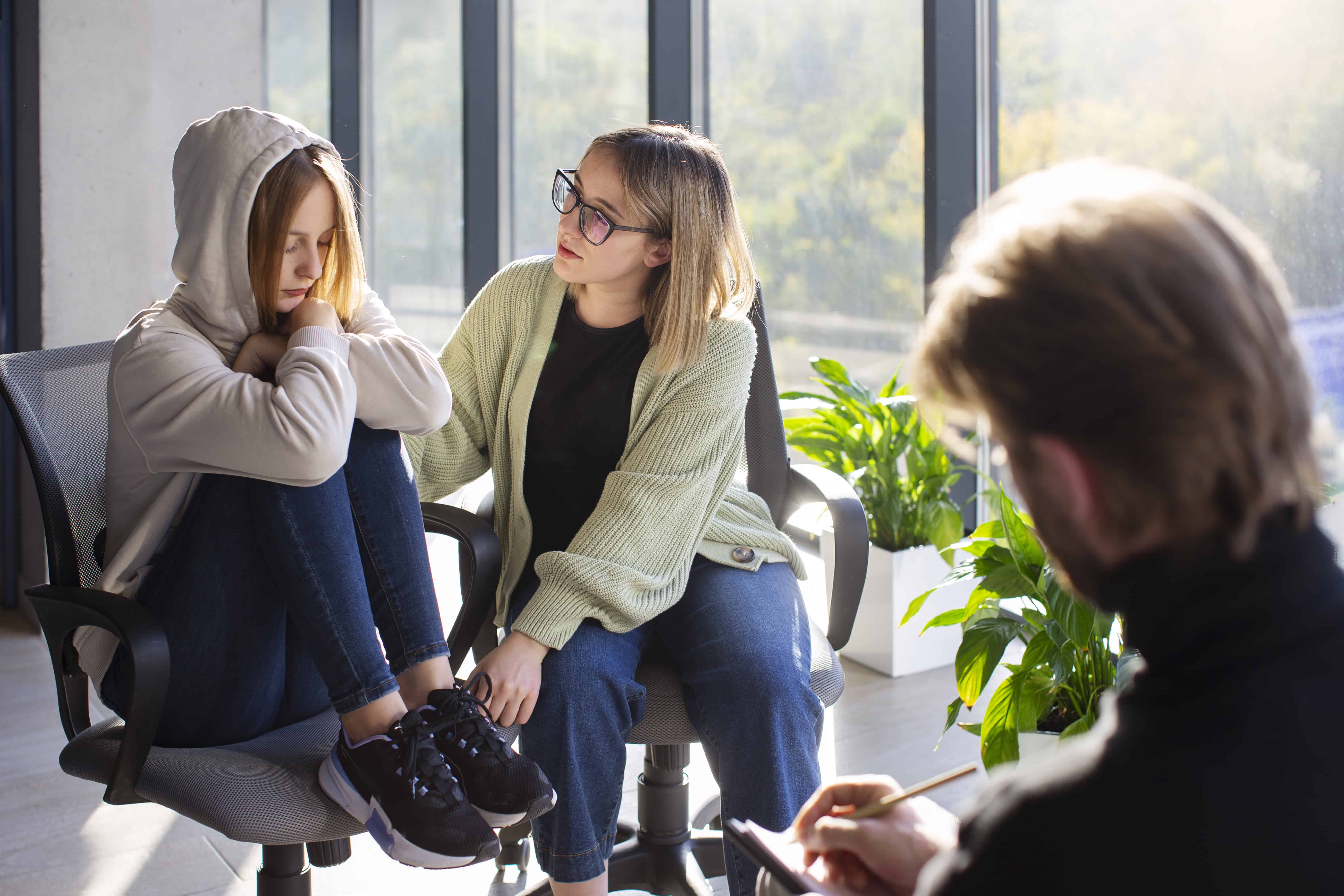 Séance de thérapie pour adolescents montrant une thérapeute accompagnant une jeune patiente en détresse, illustrant l'importance de l'alliance thérapeutique et du cadre sécurisant dans le traitement du trauma