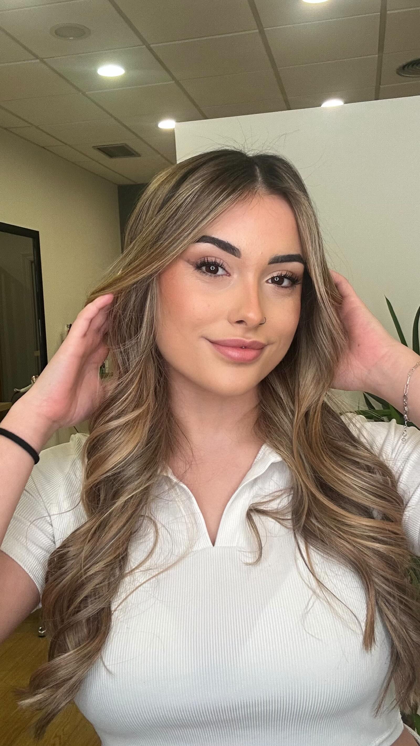 A woman relaxing in soft sunlight, surrounded by plants and warm decor, emphasizing the peaceful and rejuvenating experience of the spa.