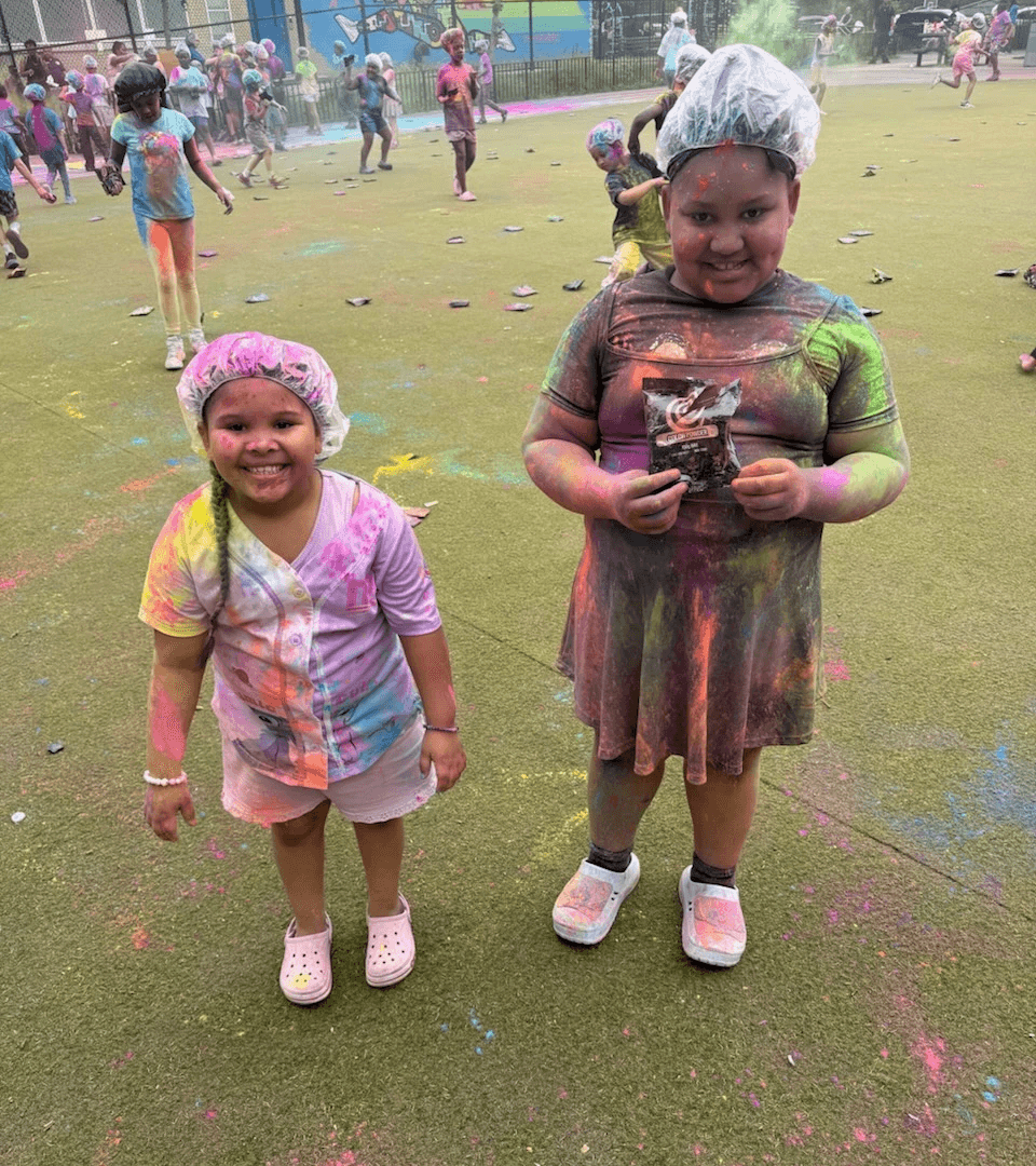 Two participants beaming and covered in powdered colors.
