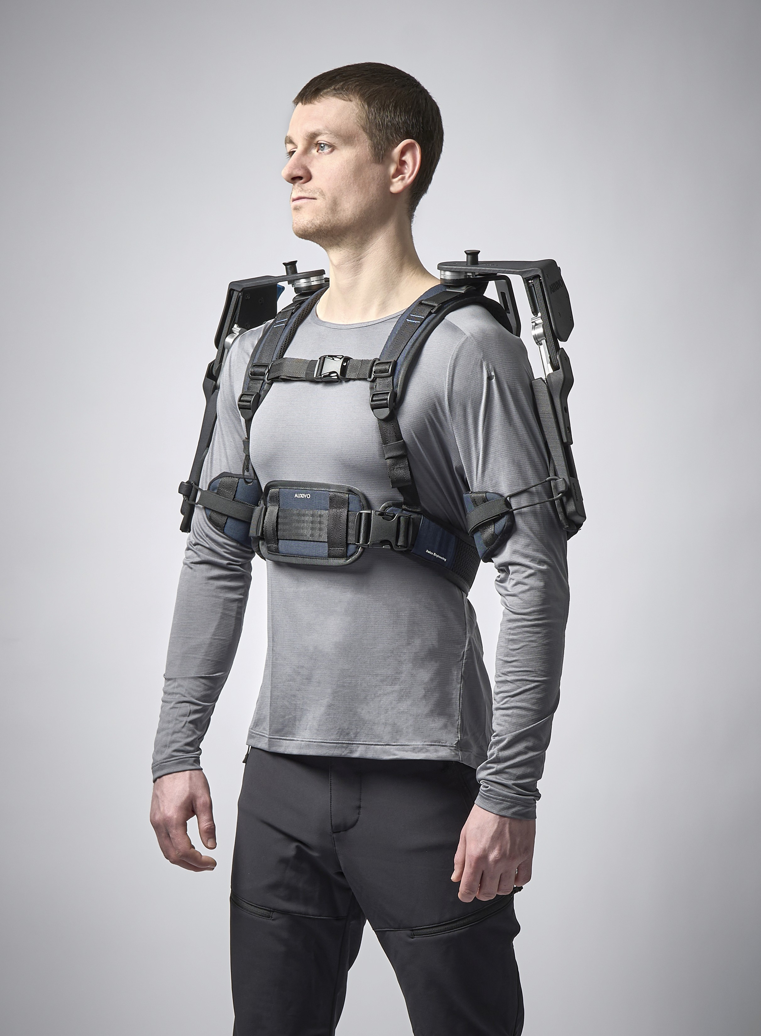 Un homme porte un exosquelette passif pour les bras.