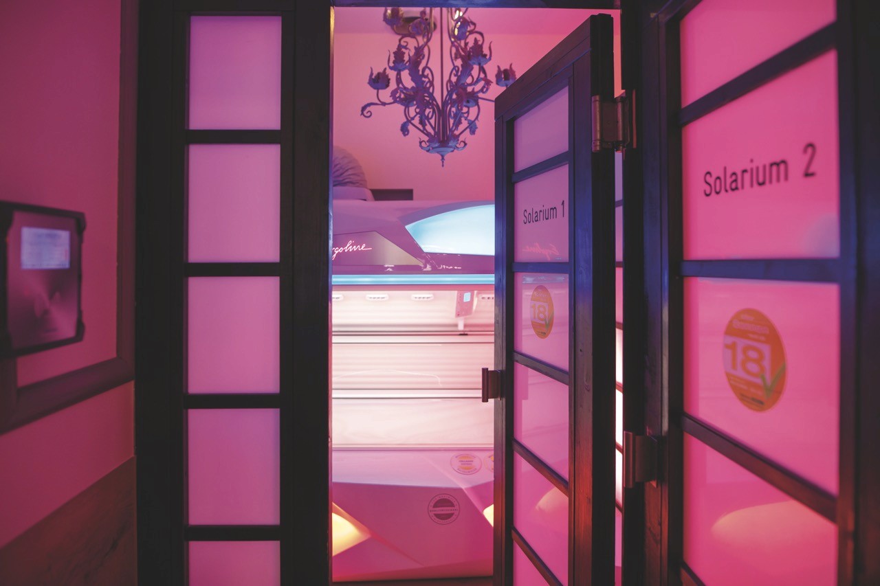 Rustic wooden cabin homes on a forested, rocky hillside road.