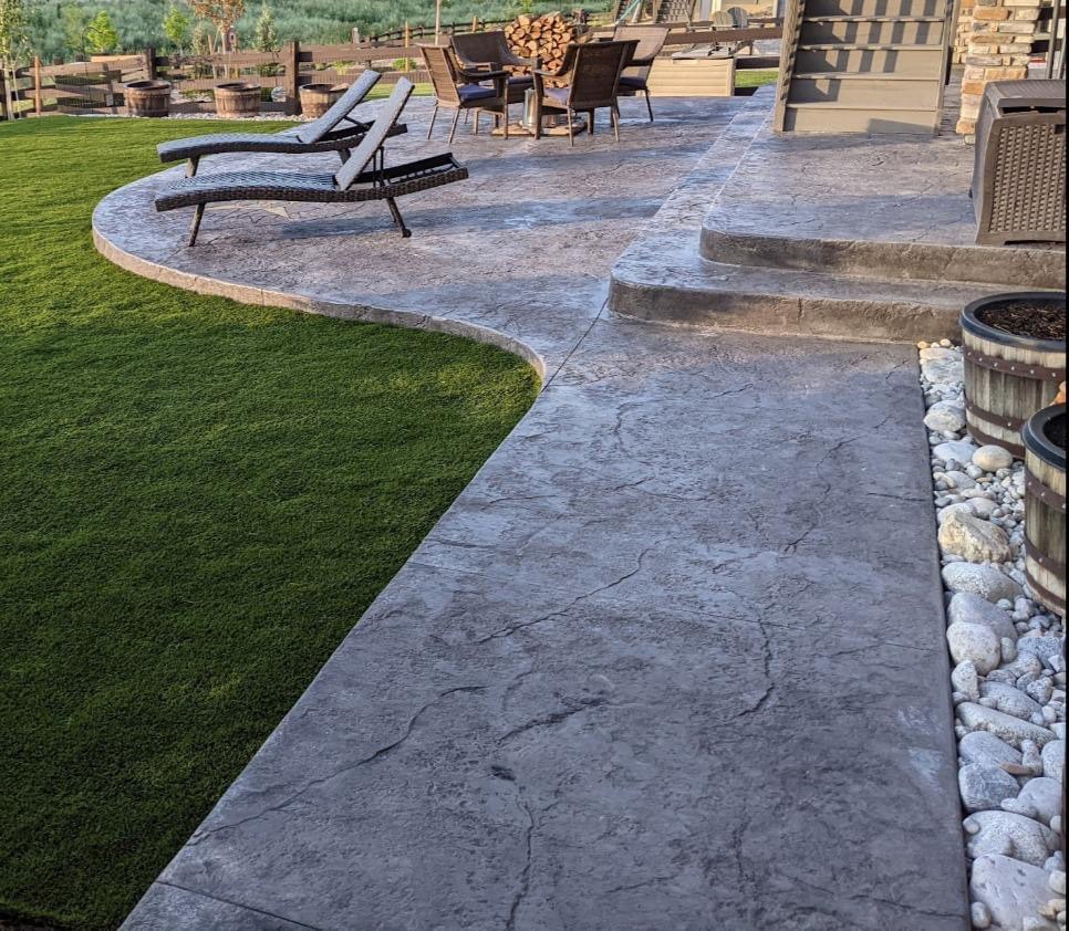 backyard landscape with artificial grass and textured concrete patio, castle rock, Macanta neighborhood, colorado 