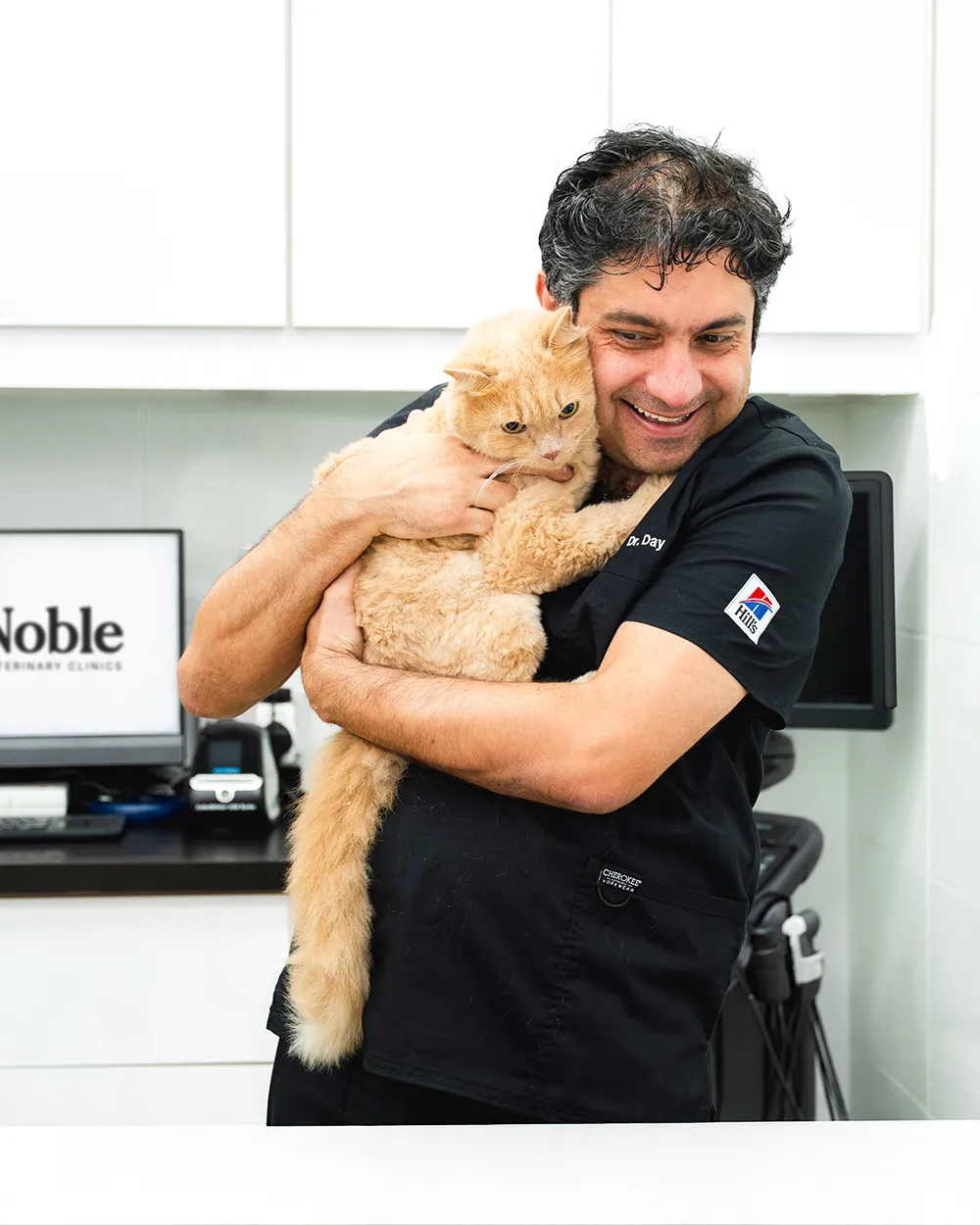 Dr. Day holds an orange cat with a chart showing vaccination protection rising to 95% by 14 to 16 weeks.