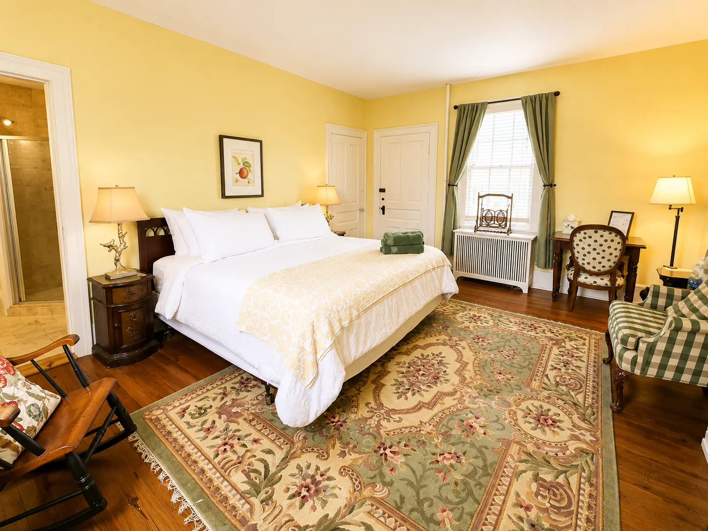 A hotel room with two double beds, hardwood floors, and a framed picture on the wall.
