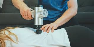 A circle of people sitting cross-legged, meditating with hands in a prayer position. Soft, warm lighting.