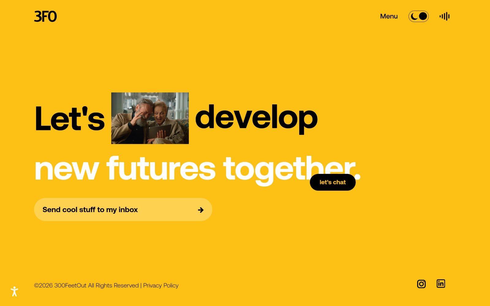 Yellow background with bold black text: "Let's develop new futures together." Image of two people smiling. Black button: "let's chat.